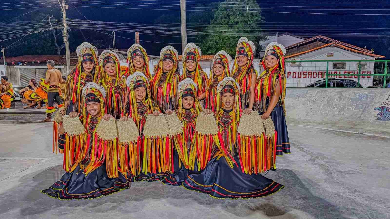 Grupo de danÃ§arinas posando com trajes vermelhos e amarelos