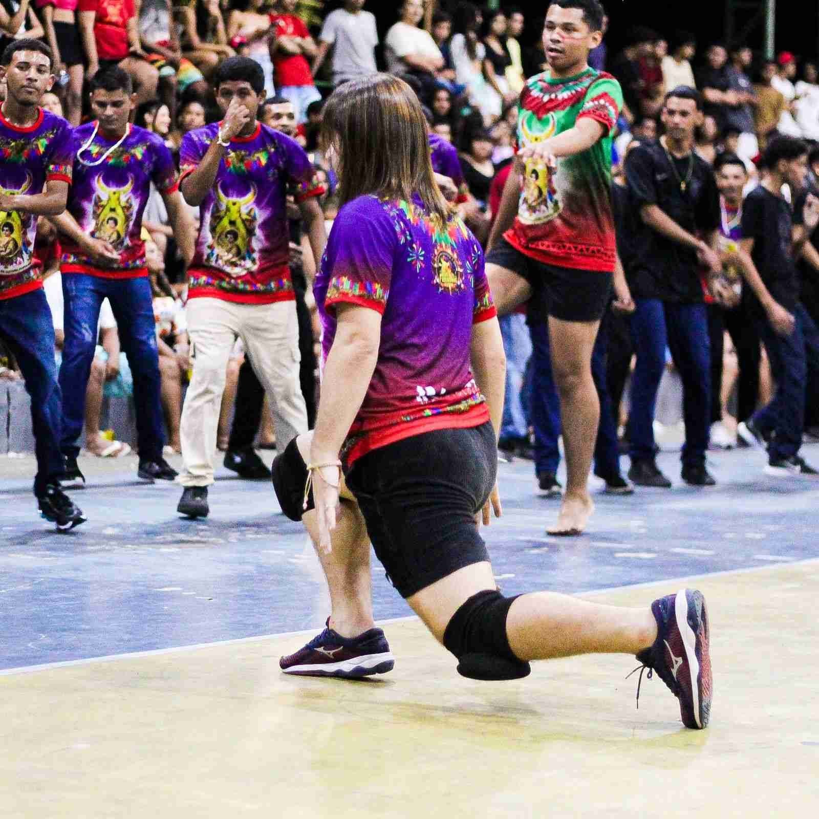Participante ajoelhada durante apresentaÃ§Ã£o do Boi Novo